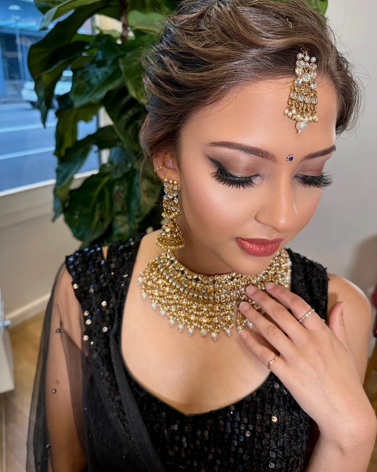 Sculpted updo, smoky eyes and gold jewellery with a black outfit