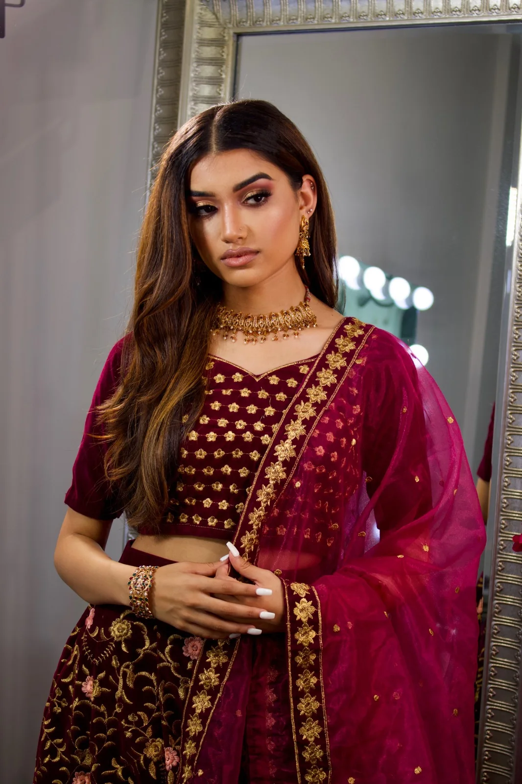 A burgundy outfit, gold jewellery and softly styled long hair