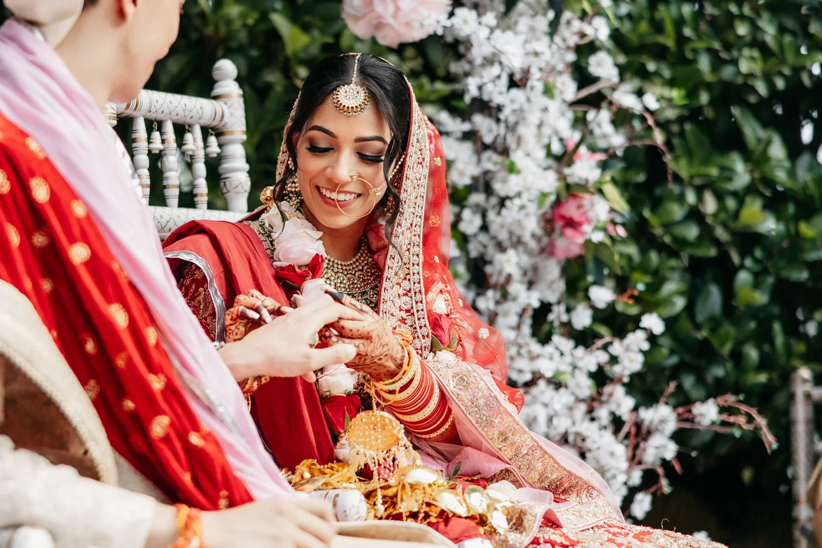 Red bridal styling, gold jewellery and a wedding ceremony moment