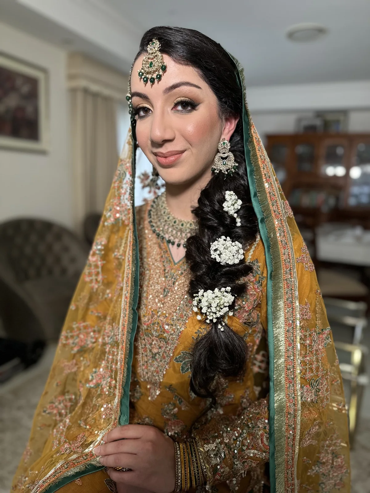 A long floral braid, gold dupatta and softly defined bridal makeup