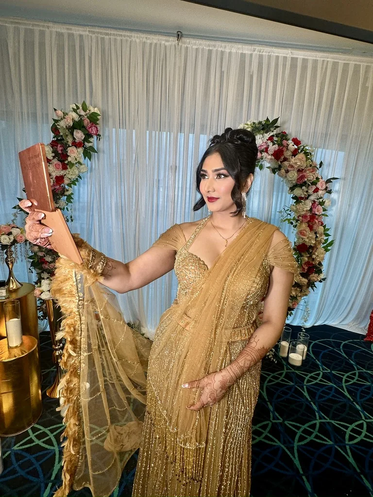 Client in a gold embellished outfit with softly framed hair, defined eyes and a rose lip