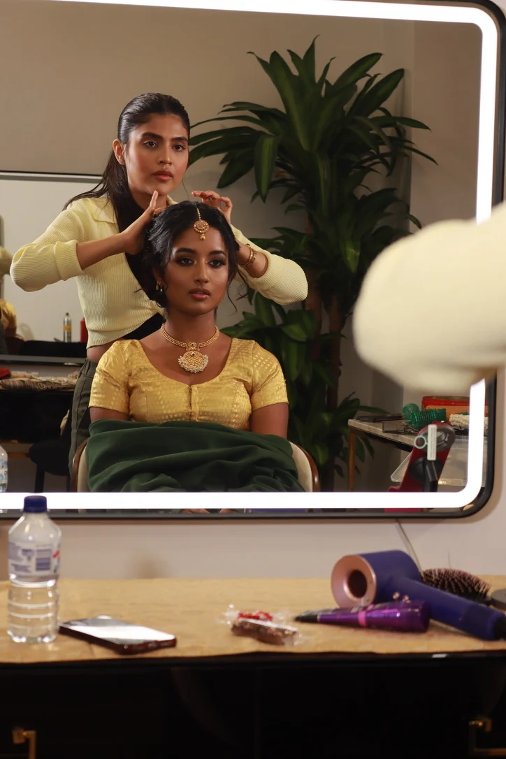 Heera refining a bride’s hair framing and jewellery at the studio mirror