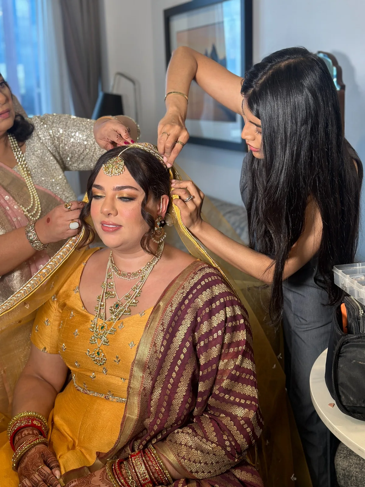 Heera helping a bride with hair and jewellery during South Asian bridal preparation
