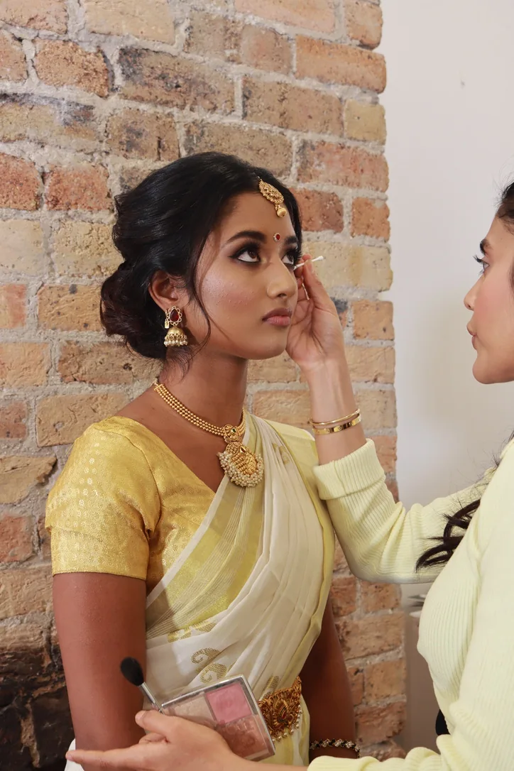 Heera refining eye makeup for a bride in ivory and gold silk