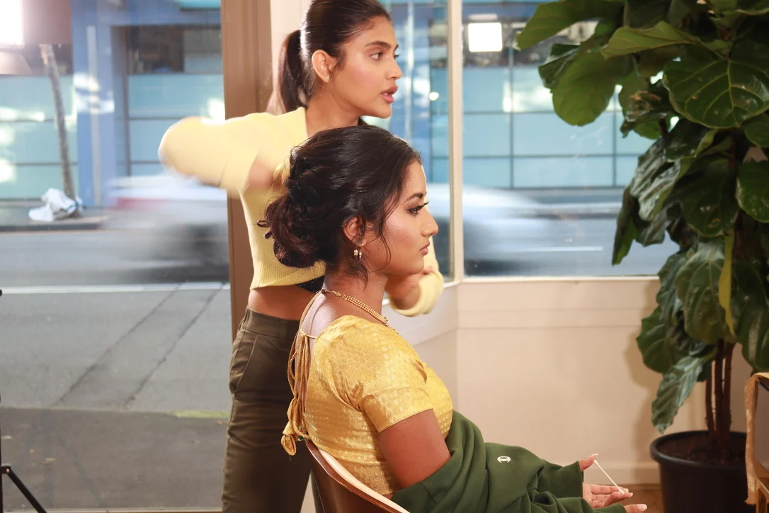 Heera refining a textured bridal updo alongside the bride’s makeup and outfit in her Ultimo studio