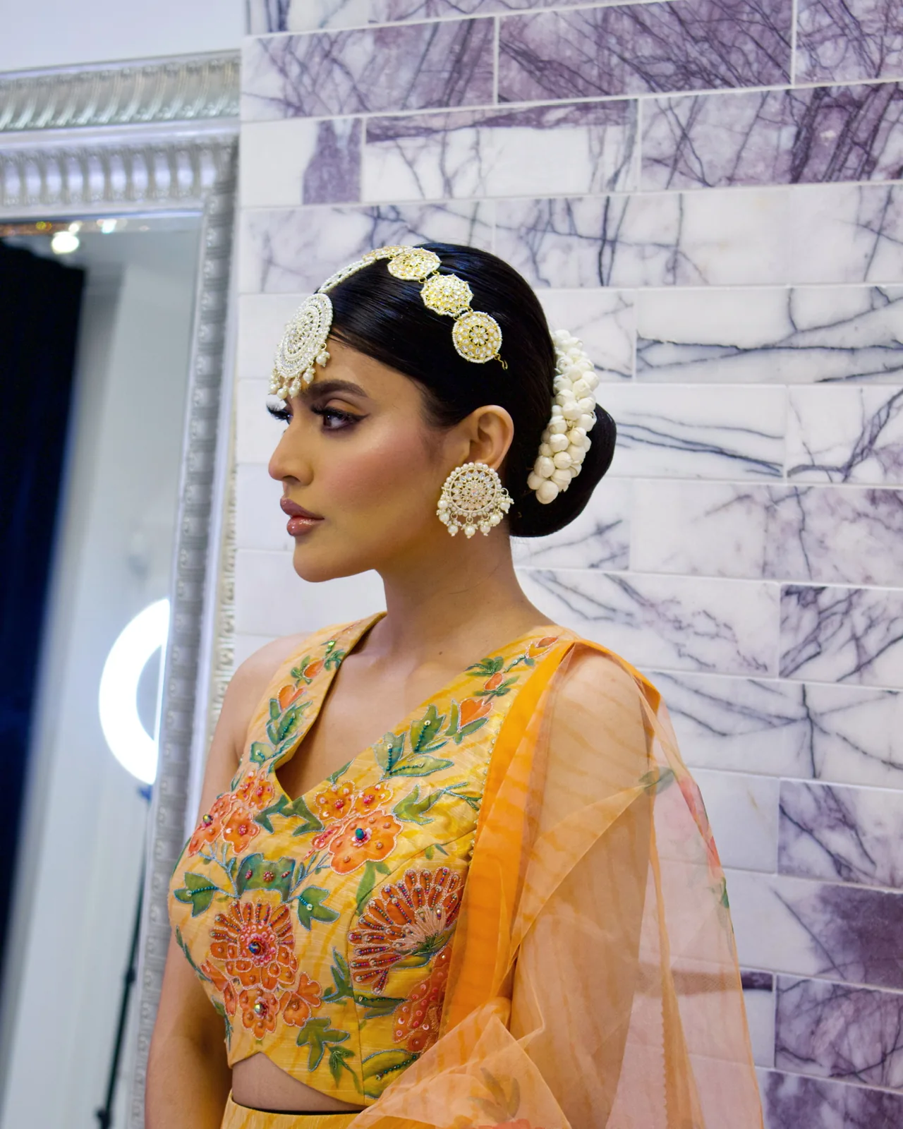 Heera exploring a traditional floral updo, gold hair jewellery and bridal makeup on herself in yellow
