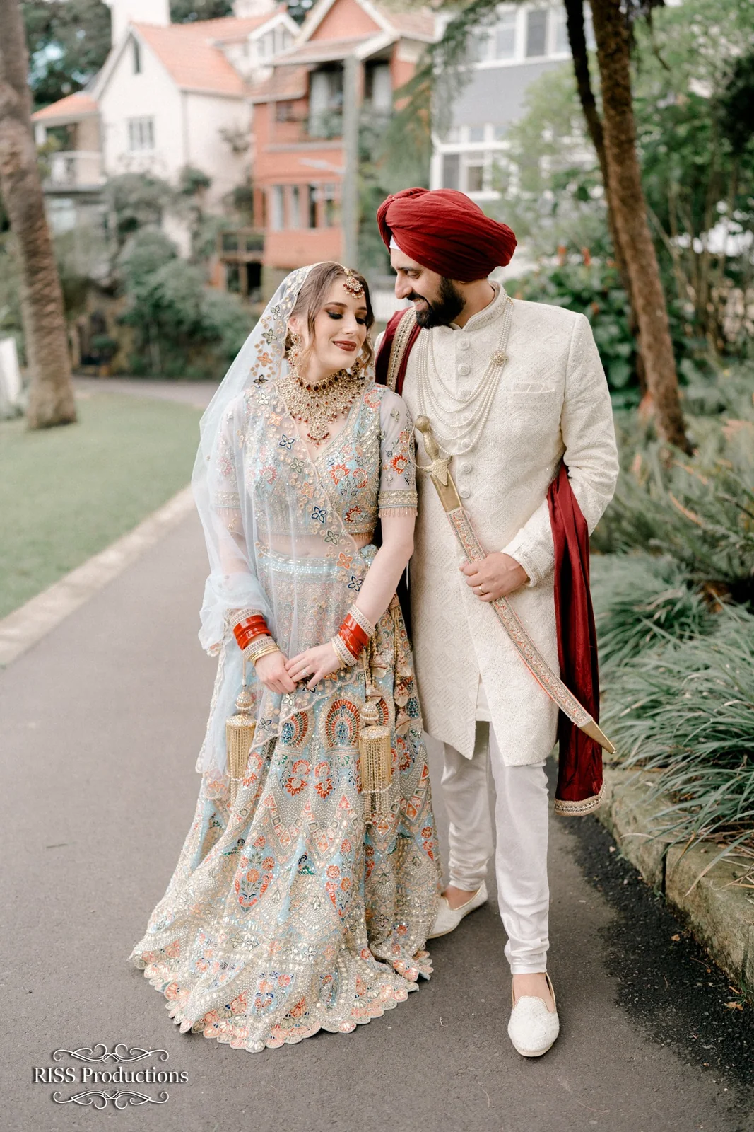 An ivory bridal outfit, softly placed dupatta and a couple’s wedding portrait