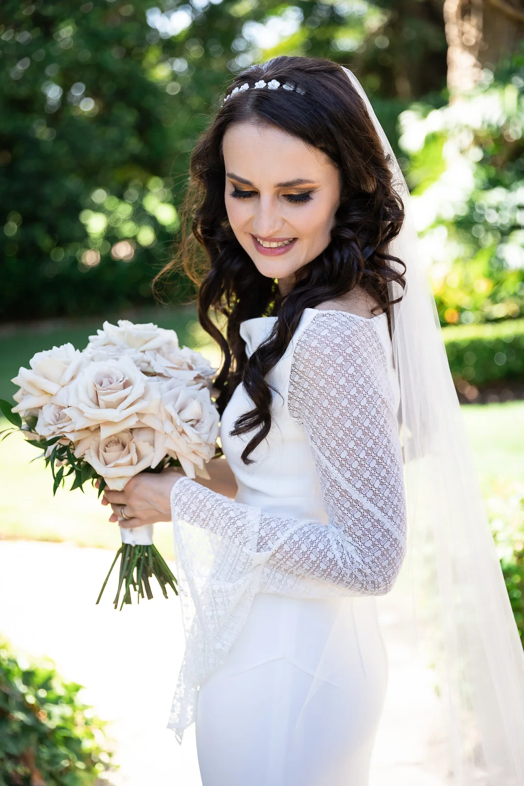 Loose dark waves, a delicate hairpiece and a white lace gown