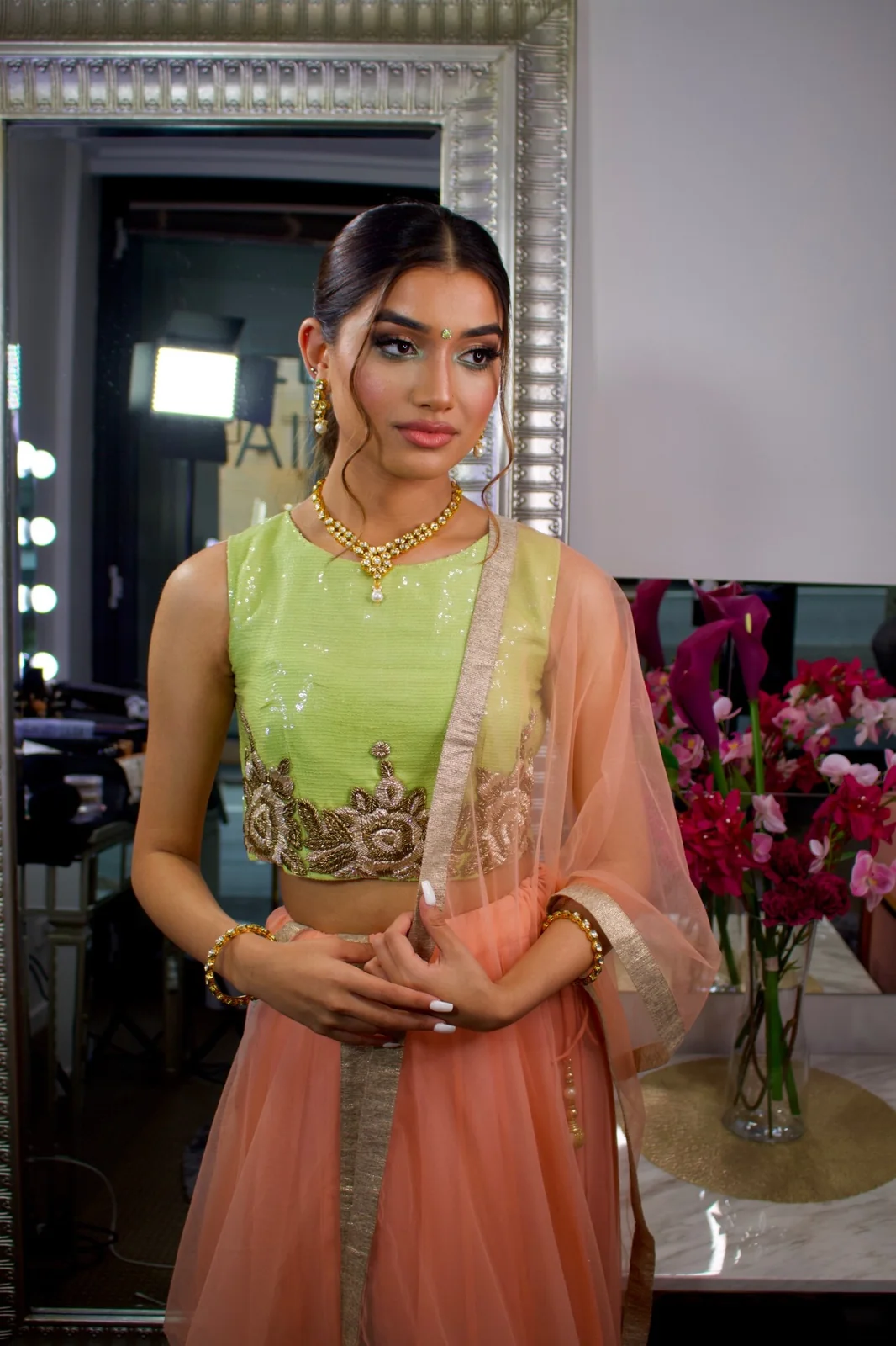 A mint top, peach skirt and dupatta with gold jewellery