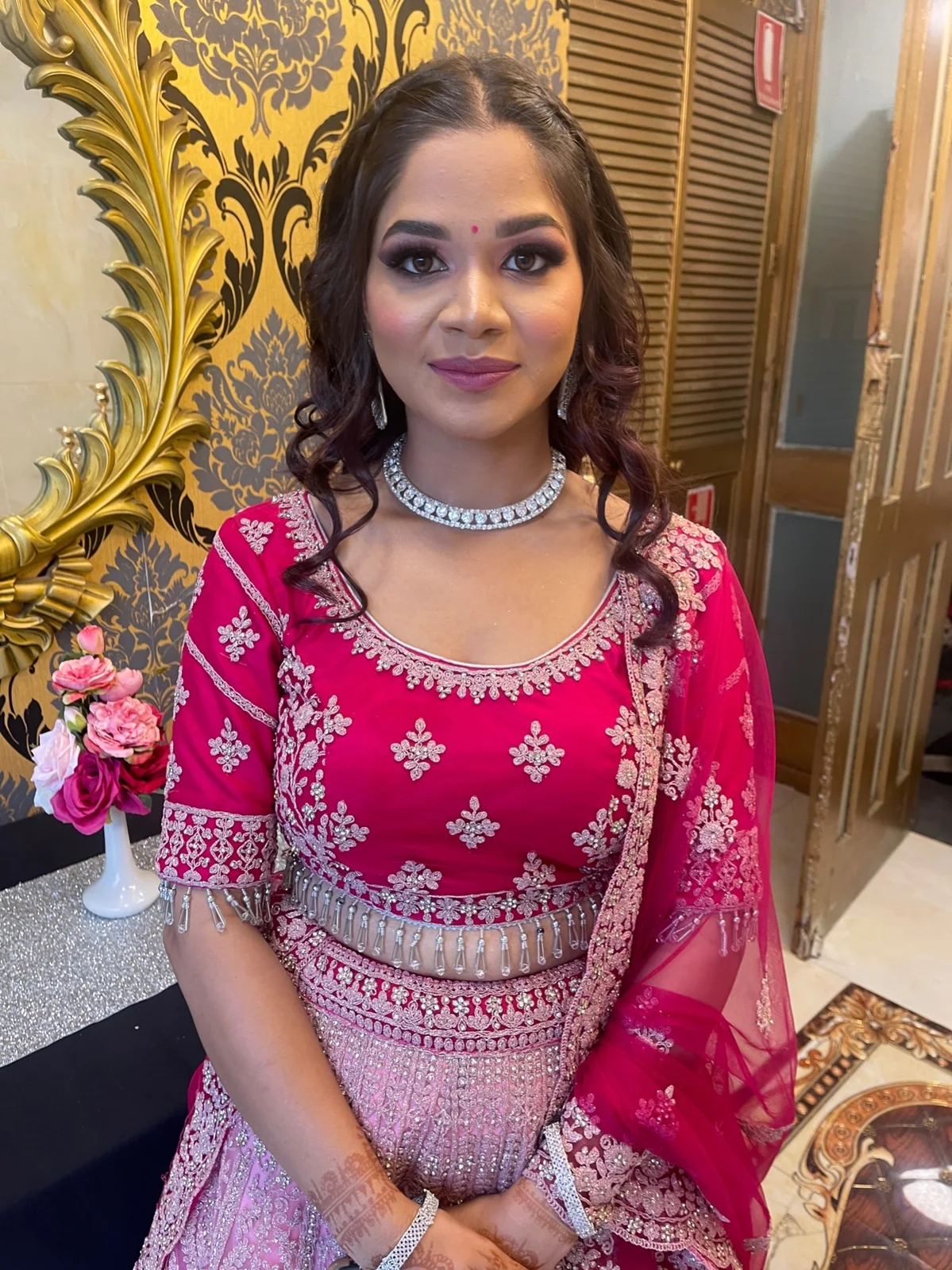 A pink embroidered outfit, silver jewellery and softly waved hair