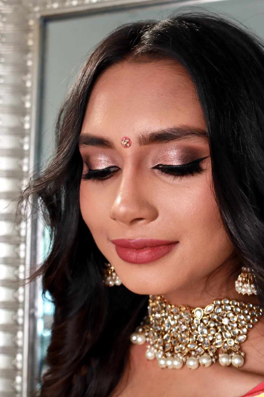 Rose-toned lips, softly shimmering eyes and loose face-framing waves