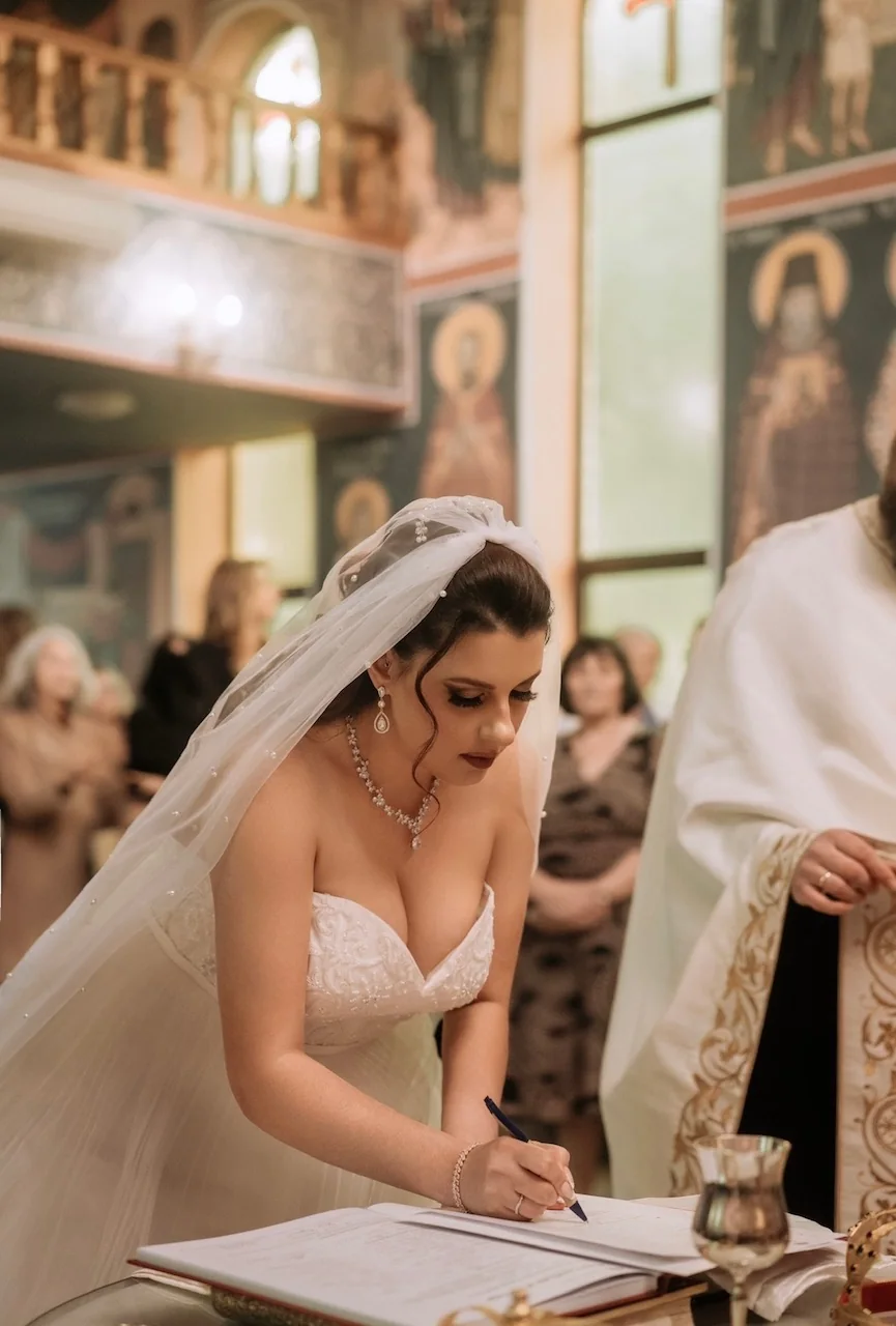 A softly styled updo, veil and white gown at the wedding register